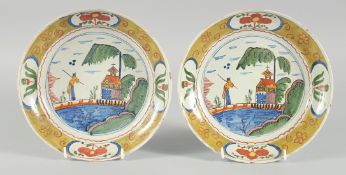 A RARE PAIR OF 18TH CENTURY DUTCH FRAMED POLYCHROME PLATES, shallow rounded form with a figure,