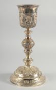 A GOOD CONTINENTAL SILVER GOBLET - CHALICE, silver-gilt with oval panels of figures in relief,