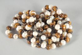 A STRING OF TIGER'S EYE AND PEARL BEADS. 48 ins long