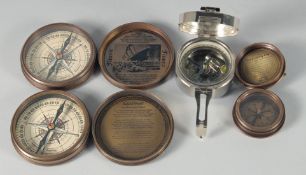 FOUR REPLICA BRASS COMPASSES.