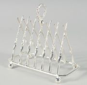 A SILVER PLATED CROSS GUNS SIX DIVISION TOAST RACK on ball feet. 7.5ins long.