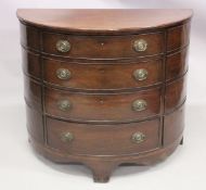 A GEORGE III MAHOGANY DEMI LUNE CHEST OF DRAWERS on four graduated drawers with oval brass