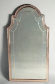 AN UPRIGHT BEVELED GLASS MIRROR with serpentine top. 2ft 9ins long 1ft 5ins wide.
