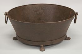 A LARGE OVAL METAL PLANTER on claw and ball feet. 26ins wide.