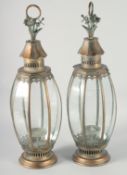 A PAIR OF TIN BULBOUS LANTERNS with carrying handles on circular bases. 27ins high.