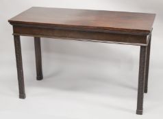 A GEORGIAN MAHOGANY SIDE TABLE with plain top on four tapering legs, with blind fret carving. 4ft