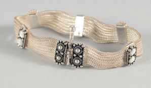 A SILVER AND MOON STONE BRACELET.