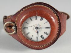A SILVER POCKET WATCH in a leather strap.