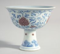 A CHINESE MING STYLE BLUE, WHITE AND UNDERGLAZE RED PEDESTAL CUP, the interior with four-character