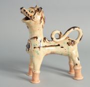 A TURKISH OTTOMAN CANNAKALE GLAZED POTTERY FIGURE OF A LION, 20cm long.