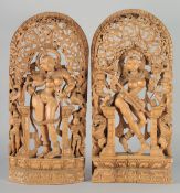 A PAIR OF THAI WOODEN WALL CARVINGS, each depicting a deity amongst pierced foliate decoration, each