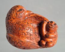 A JAPANESE BOXWOOD NETSUKE OF BIRD carrying a monkey.