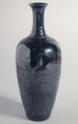 A CHINESE AUBERGINE GLAZE PORCELAIN VASE, with raised decoration depicting dragons amongst waves,