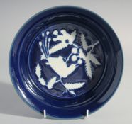 A RARE CHINESE BLUE AND WHITE RESERVE-DECORATED PORCELAIN DISH, the centre with a bird and flora,