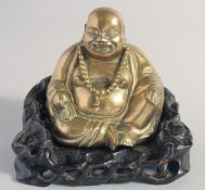A CHINESE BRASS BUDDHA on a fitted carved and pierced hardwood base.