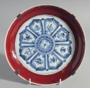 A CHINESE BLUE, WHITE AND COPPER RED DISH, decorated with radiating medallion to the centre,
