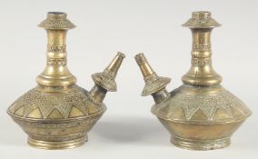 A PAIR OF EARLY ISLAMIC BRASS HUQQA BASES, with bands of foliate decoration, 25cm high.