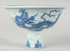 A CHINESE BLUE AND WHITE PORCELAIN STEM CUP, decorated with dragons on a wave-pattern ground,