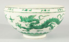 A CHINESE GREEN ENAMELLED PORCELAIN BOWL, decorated with dragons and clouds, 24.5cm diameter.