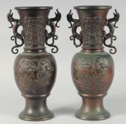 A PAIR OF JAPANESE TWIN HANDLE BRONZE VASES, relief decorated with birds and native flora, 35.5cm