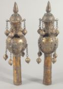 A PAIR OF ISLAMIC BRASS CEREMONIAL FINIALS, each with hanging bells and inset with turquoise stones,