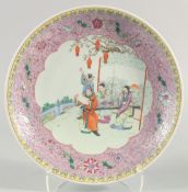 A LARGE CHINESE FAMILLE ROSE PORCELAIN DISH, painted with a central panel of figures in a garden