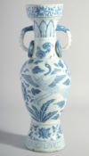 A CHINESE YUAN STYLE BLUE AND WHITE GLAZED POTTERY TWIN HANDLE VASE, painted with birds and flora,