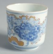 A JAPANESE BLUE AND WHITE PORCELAIN CUP, decorated with foliate motifs and gilt highlights, 6.5cm