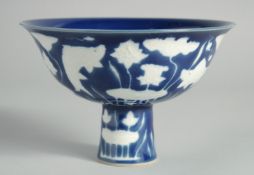 A CHINESE SACRIFICIAL BLUE AND WHITE STEM CUP, the exterior decorated with fish and aquatic flora,