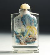 A CHINESE REVERSE PAINTED GLASS SNUFF BOTTLE with hardstone stopper, decorated with a monkey to