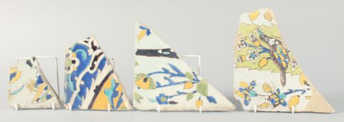 FOUR 17TH CENTURY PERSIAN SAFAVID TILE FRAGMENTS, largest piece 29cm at widest point, (4).