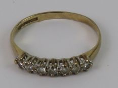 A 9ct gold and diamond seven stone half eternity ring, hallmarked 375, size J-K, 1.1g.
