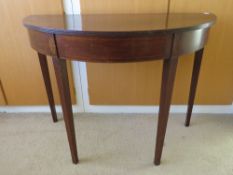 Ad Edwardian mahogany demi-lune table raised over square tapering legs, measuring 96 x 47 x 70cm.