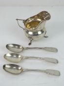 A Chester hallmarked cream jug raised over three feet, standing 7cm high,