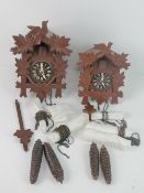 Two black forest cuckoo clock c. early 20th century, each with pendulum and weights.