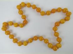 A Butterscotch amber type bead necklace, having alternating sized beads on double cord,