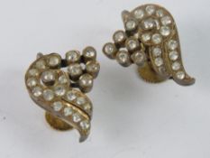 A pair of vintage screw back yellow metal white stone earrings.
