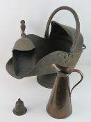 A copper coal scuttle with shovel, together with a copper jug and a metal bell.