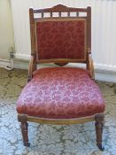 A single low Edwardian fireside or nursing chair having floral inlay, oversprung seat,