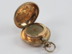 A hallmarked rose gold sovereign holder having push button release and vine engraving throughout,