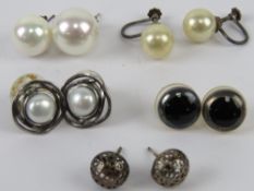 A pair of silver and pearl stud earrings together with two other pairs of silver earrings and two