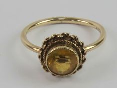 A 9ct gold and citrine ring, central round cut stone in rope twist pattern setting, hallmarked 375,