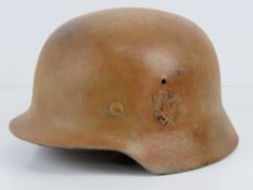 A WWII German M40 helmet having partial decal upon with liner and chin strap.
