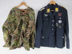 A quantity of assorted repro WWII German tunics, trousers and caps.