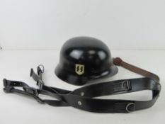 A pair of German 'Y' straps, together with a reproduction German 'SS' black helmet.