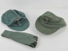 A reproduction WWII German side cap together with two reproduction ski hats.