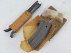 An M16 bipod , M16 sling and three inert un-issued magazines.