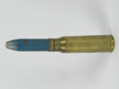 An inert 23mm cannon round 17.5cm in length.