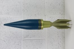An inert 90mm French HESH round (blue) measuring 58cm in length.