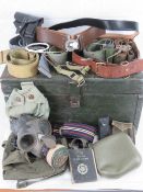 A wooden US Marine chest having a quantity of gas masks in case, webbing belts, holster,